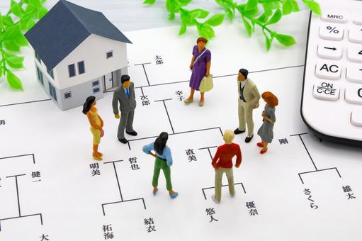 相続関係図の上に置かれた家の模型と、家族を表す人形。不動産の相続は関係者が多く分けにくいことを表しています。